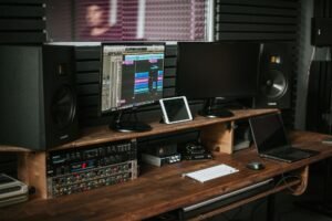 Puesto de produccion musical con monitores de estudio sobre el escritorio
