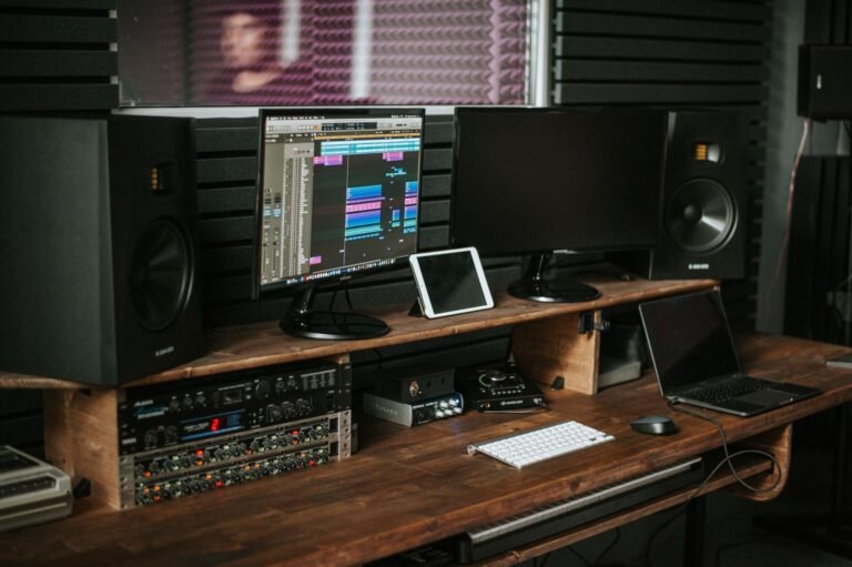 Puesto de produccion musical con monitores de estudio sobre el escritorio