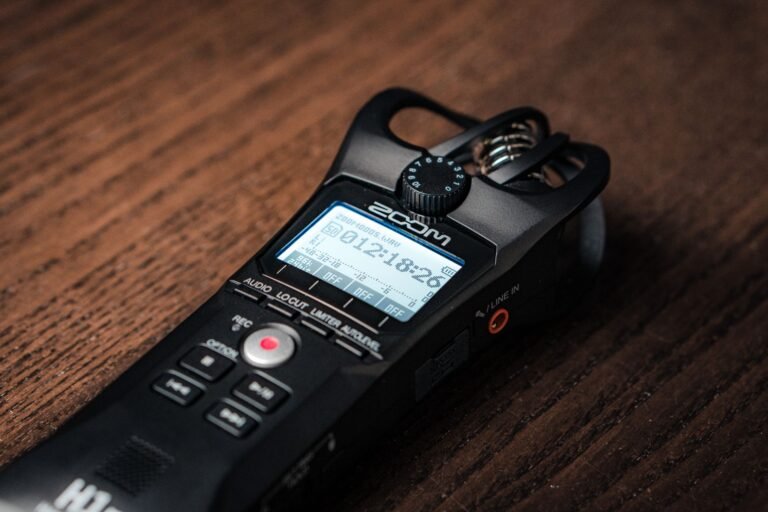 Primer plano de una grabadora de audio digital sobre una mesa de madera