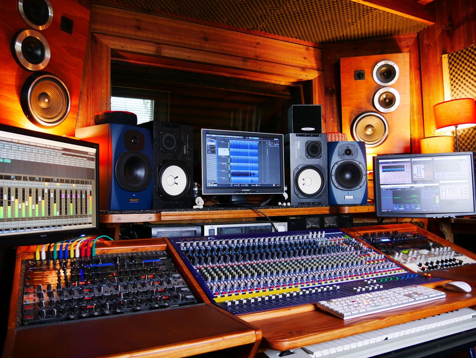 Mesa de mezclas y monitores de estudio en la posición de escucha de un estudio