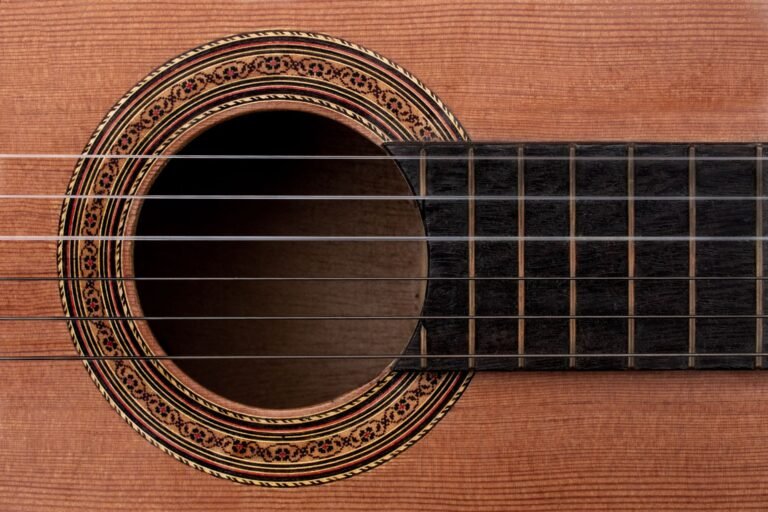 Primer plano de la tapa de una guitarra clásica: veta de la madera, boca y roseta