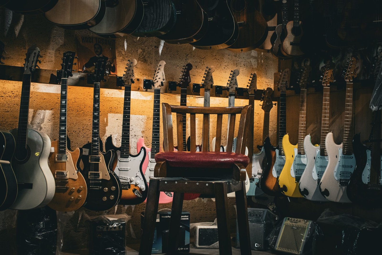 Tienda de música con guitarras clásicas, acústicas y eléctricas colgadas en la pared