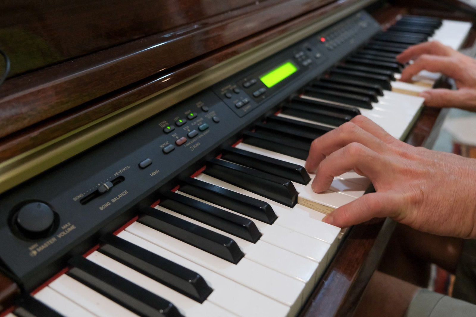 Manos tocando las teclas de un piano digital en primer plano