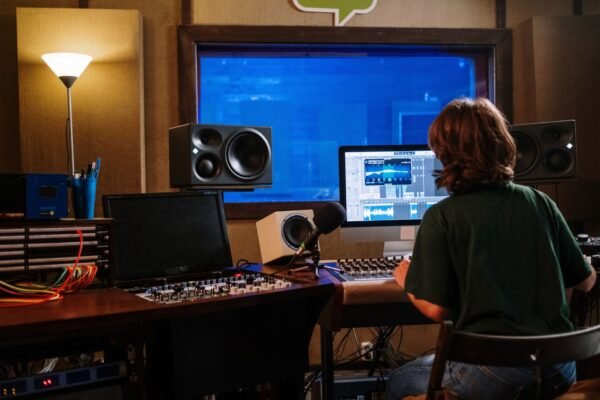 Técnico de sonido mezclando en un estudio con monitores y un DAW en pantalla