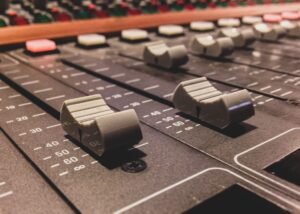 Faders y controles de una mesa de mezclas de estudio en primer plano