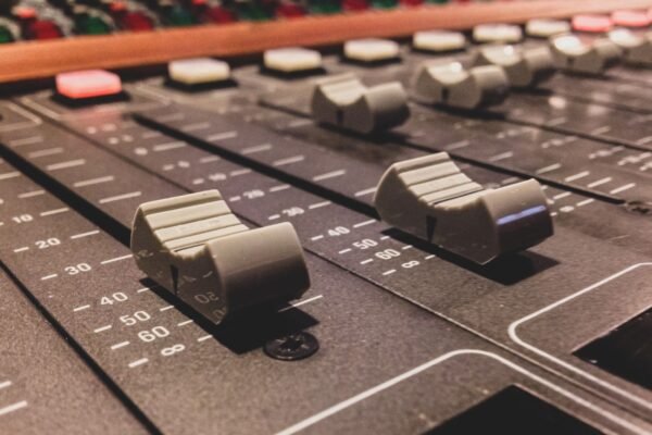 Faders y controles de una mesa de mezclas de estudio en primer plano