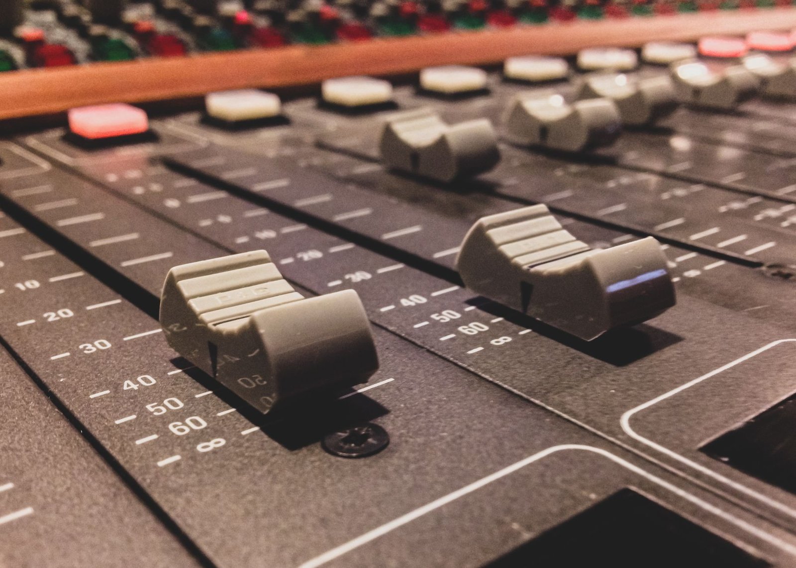 Faders y controles de una mesa de mezclas de estudio en primer plano