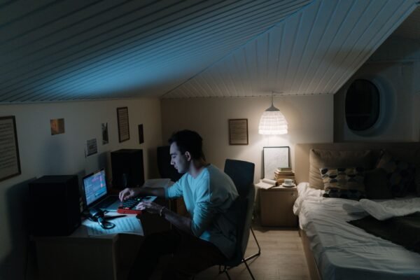 Home studio en un dormitorio: portátil, controlador MIDI y monitores junto a la cama
