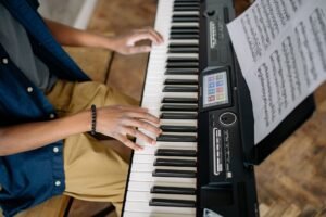 Persona tocando un piano digital con partitura, vista general