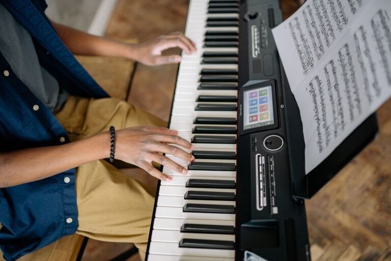 Persona tocando un piano digital con partitura, vista general