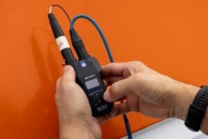 Manos conectando un cable XLR a la grabadora portátil Zoom H1 XLR