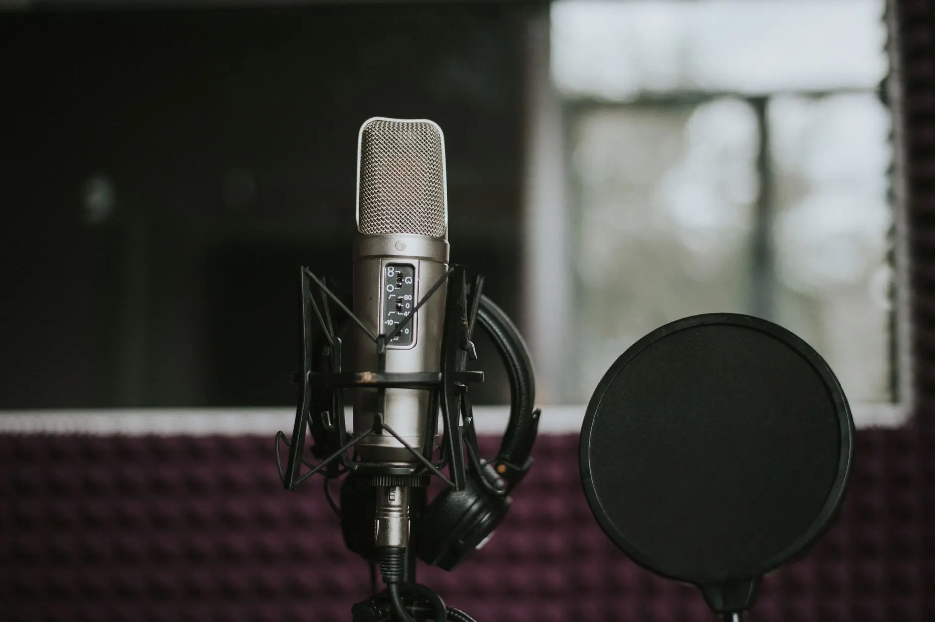 Micrófono de estudio con filtro antipop delante en una sala de grabación