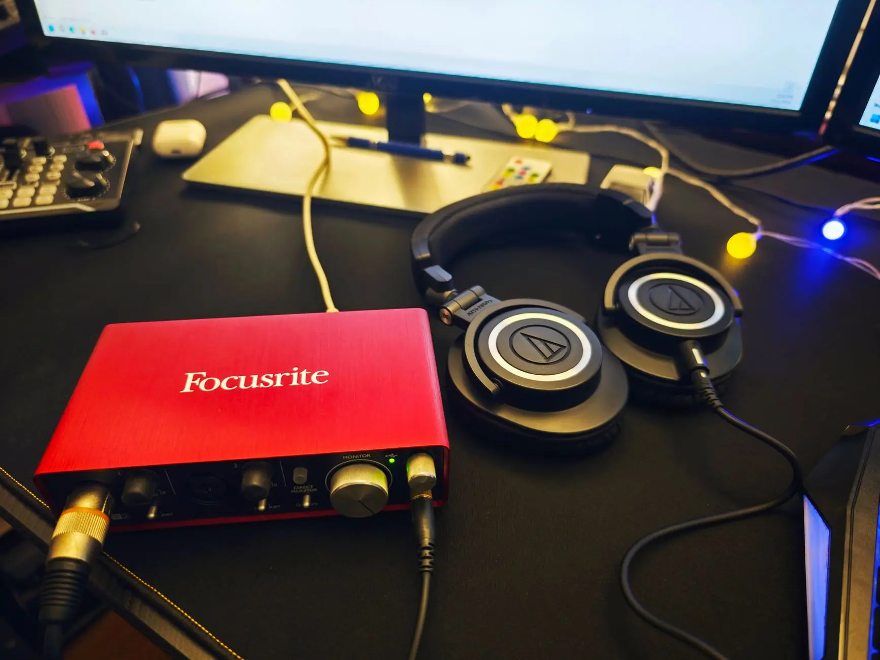Interfaz de audio y auriculares sobre un escritorio de home studio