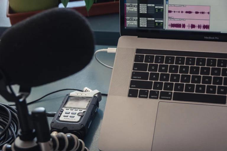 Micrófono y portátil sobre una mesa, configuración para grabar audio en casa